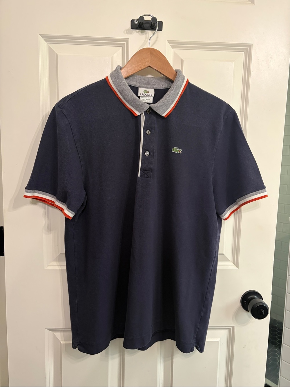 Lacoste Men's Navy Polo with Contrast Grey/orange striped Trim. Size L.
